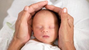 Baby held in human hands